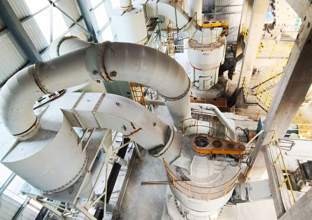 Engineer inspecting a large industrial grinding mill in a factory