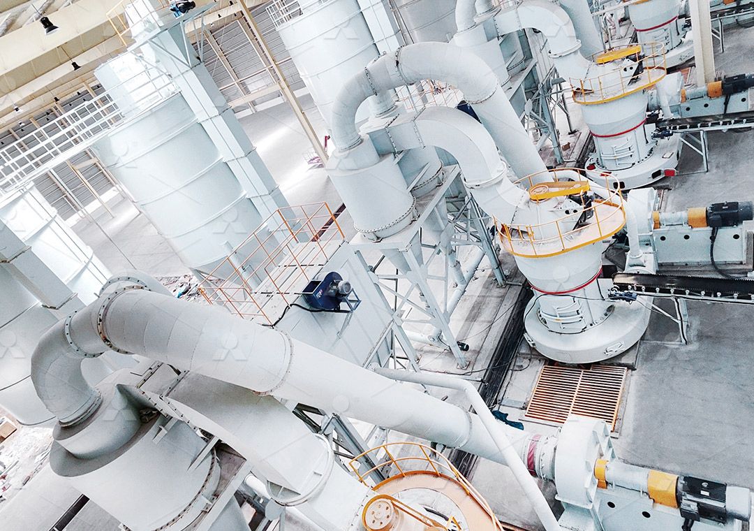 A service technician providing maintenance support on a large grinding mill in a factory