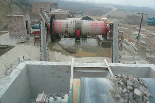 A traditional ball mill in operation, showing the large rotating drum