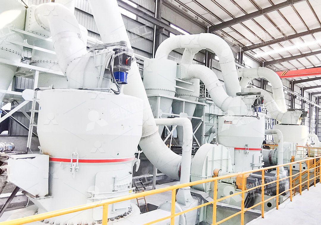 Industrial grinding mill setup in a factory showing main mill body and auxiliary equipment