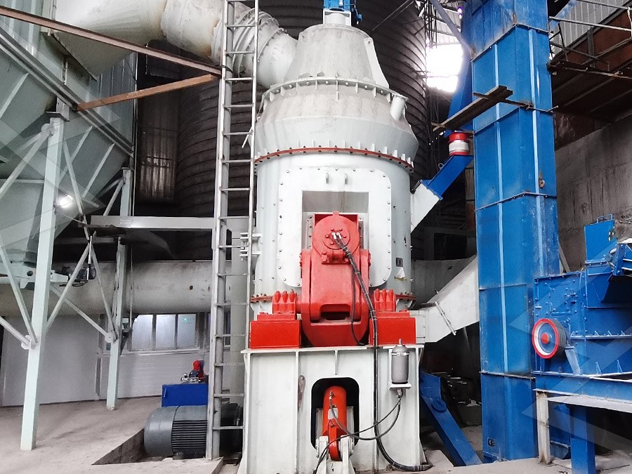 Operator using digital control panel to monitor power consumption and adjust grinding parameters on a vertical mill