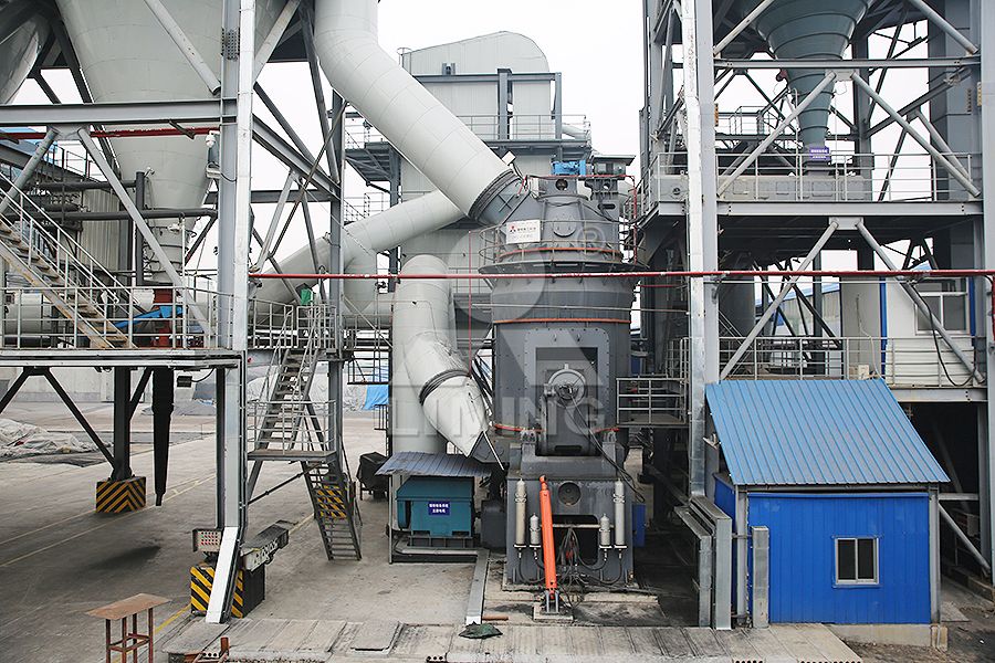 Close-up of a grinding roller and table in a vertical mill processing slag, showing the material bed